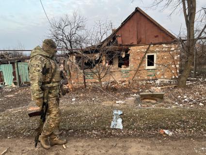 Донецкая область. г.Бахмут (Артемовск). Боец ЧВК `Вагнер` идет по дороге мимо разрушенных частных домов в восточной части города, полностью контролируемой российскими войсками.