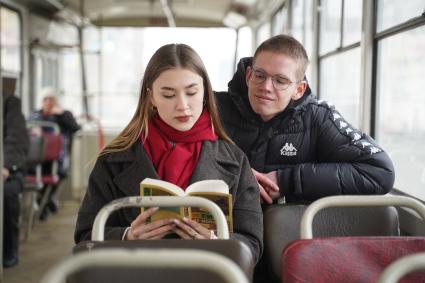 Самара. Юноша и девушка читают книгу Ги де Мопассана в автобусе.