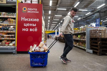 Санкт-Петербург. Мужчина с наполненной продуктовой корзиной в супермаркете.