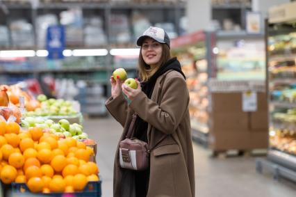 Санкт-Петербург. Девушка около прилавка с фруктами в супермаркете.