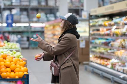 Санкт-Петербург. Девушка около прилавка с фруктами в супермаркете.