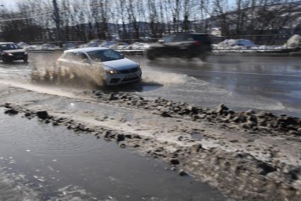 Мурманск. Автомобили на подтопленной из-за таяния снега улице.