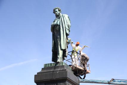 Москва. Сотрудники коммунальных служб моют  после зимы памятник Александру Пушкину  на Пушкинской площади.