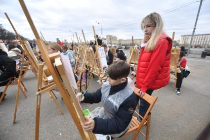 Москва.  Мальчик рисует  на фестивале `Пасхальный дар` в Парке Горького.