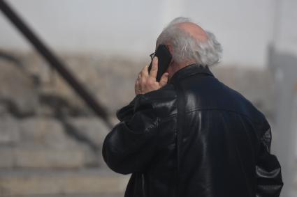 Екатеринбург. Пожилой мужчина говорит по мобильному телефону