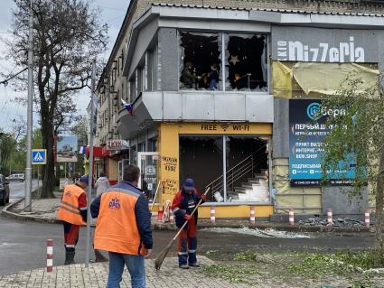 Донецк. Коммунальщики убирают разбитые стекла у ТЦ, пострадавшего в результате обстрела ВСУ.