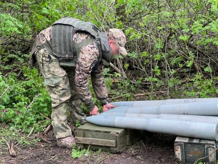 Запорожская область. Военнослужащий Отдельного разведбата 19-й мотострелковой дивизии поднимает боеприпас.