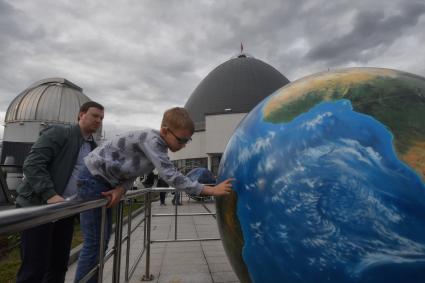 Москва. Астрономическая площадка `Парк неба` Московского планетария. Посетители у Глобуса Набокова - модели земного шара.