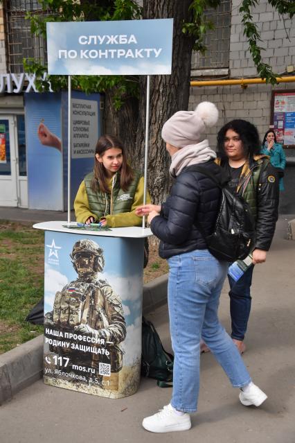 Москва.  Девушки  на улице у стойки записи  на службу по контракту.