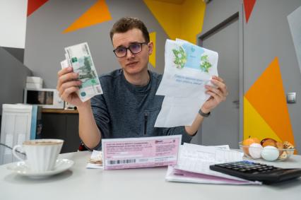 Санкт-Петербург. Мужчина изучает квитанции на оплату коммунальных услуг.
