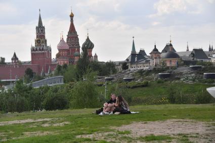 Москва. Девушки отдыхают на газоне в природно-ландшафтном парке `Зарядье`.