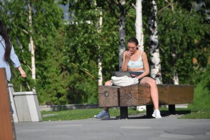 Москва. Девушка с ноутбуком на скамейке в парке `Зарядье`.