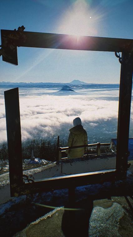 Пятигорск. Девушка сидит на фоне рамки для фотографирования на вершине горы Машук.