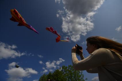 Москва.  Девушка фотографирует воздушные змеи во время фестиваля `Пестрое небо` в музее-заповеднике `Царицыно`.