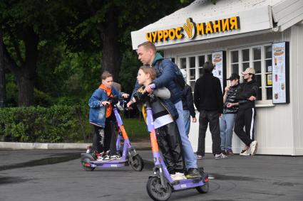 Москва. Горожане  катаются на самокатах в Парке Горького.