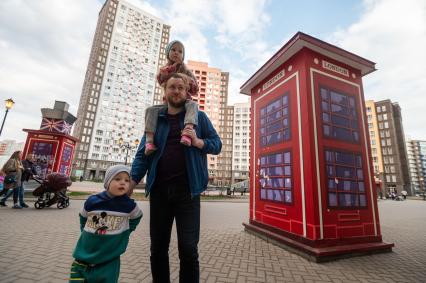 Ленинградская область. Город Кудрово. Мужчина с ребенком на улице города.