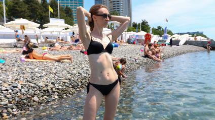 Сочи. Девушка загорает на пляже Черного моря.