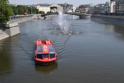 Москва. Прогулочный катер плывет мимо плавающих фонтанов на Водоотводном канале возле пешеходного Третьяковского моста в районе Кадашевской и Болотной набережных.