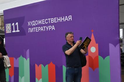 Москва. Посетитель на IX ежегодном книжном фестивале `Красная площадь`.