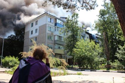 Белгородская область. г.Шебекино. Девушка смотрит на дымящийся жилой дом, обстрелянный артиллерией ВСУ.
