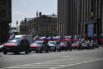 Москва. Колонна машин с  флагами России у здания Государственной Думы РФ  в день празднования Дня России.