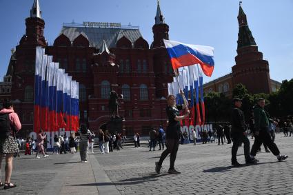 Москва.  Женщина с Российским флагом на Манежной площади  в День празднования Дня России.