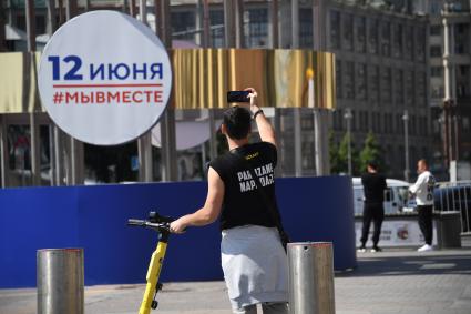 Москва.  Мужчина фотографирует на улице  в День празднования Дня России.