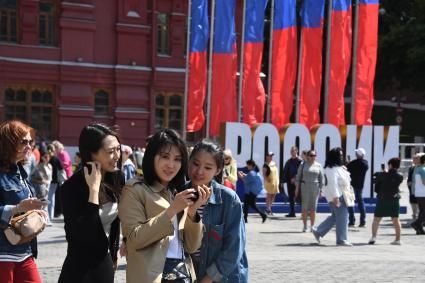 Москва.  Туристы на Манежной площади  в День празднования Дня России.