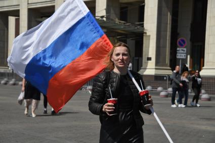 Москва.  Женщина с Российским флагом на Манежной площади  в День празднования Дня России.