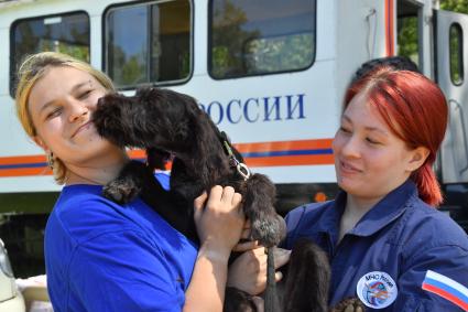 Московская область. Раменское. Сотрудники кинологического отряда Центроспас  МЧС России с собакой  перед началом тренировки на учебной площадке в лесопарковой зоне.