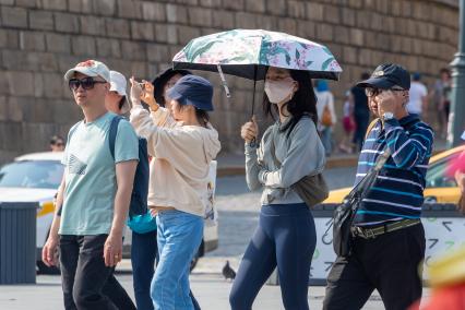 Москва. Китайские туристы в защитных масках на улице города.