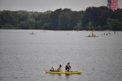 Москва. Люди плавают на sup-борде у пляжа в Строгино.