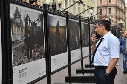 Москва. Мужчина у стендов с  фотографиями выставки лауреатов Всероссийского конкурса военной журналистики, которая открылась на Арбате.