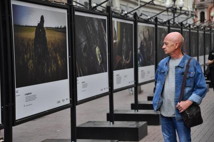 Москва. Мужчина у стендов с  фотографиями выставки лауреатов Всероссийского конкурса военной журналистики, которая открылась на Арбате.