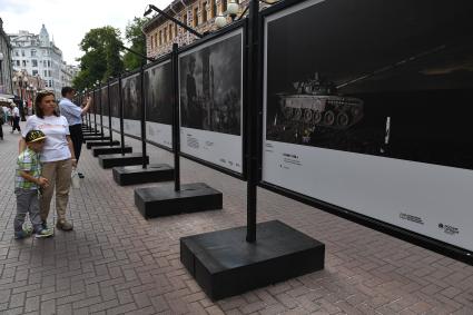 Москва. Прохожие у стендов с  фотографиями выставки лауреатов Всероссийского конкурса военной журналистики, которая открылась на Арбате.