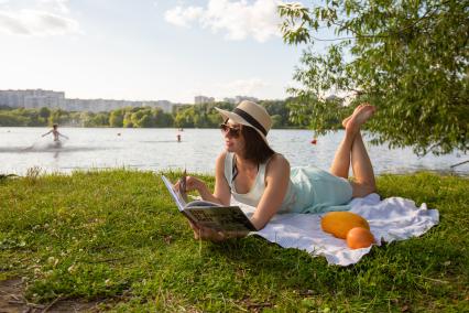 Москва. Девушка загорает с книгой на пляже Серебряный бор № 2.