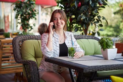 Пермь.  Девушка сидит в кафе и разговаривает по мобильному  телефону.