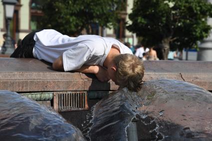 Москва. Мальчик мочит голову в фонтане на Манежной площади.