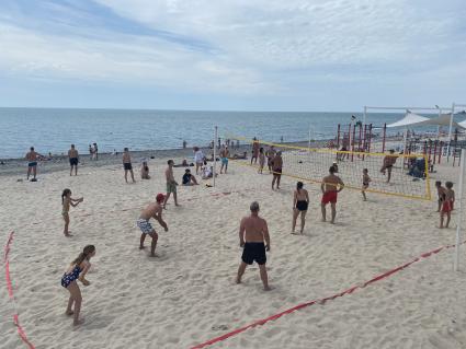 Сочи. Люди играют в волейбол на пляже Черноморского побережья.