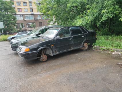 Москва. Автомобиль ВАЗ-2115 без колес во дворе на парковке.