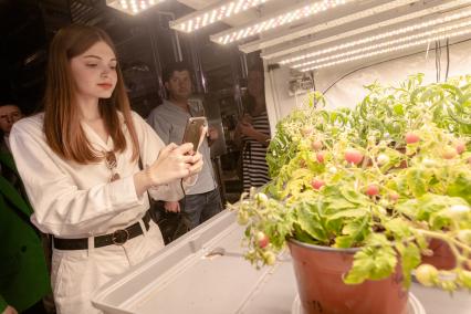 Москва. Девушка фотографирует в лаборатории искусственного климата Российского государственного аграрного университета - МСХА имени К.А. Тимирязева.