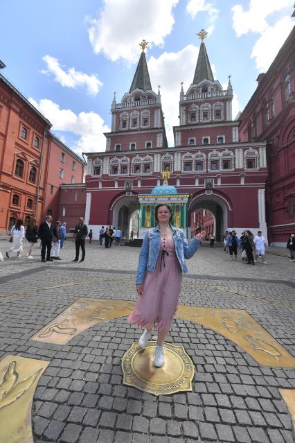 Москва. Корреспондент `Комсомольской правды ` Александра Будаева стоит на Нулевом километре всех дорог России  на Манежной площади, у Воскресенских ворот и  Иверской часовни.