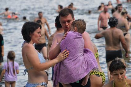 Москва. Пара с ребенком на пляже озера Белое в районе Косино-Ухтомское.