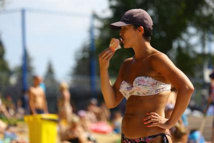 Москва. Женщина ест мороженое на пляже `Динамо`.