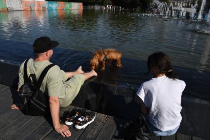 Москва.   Мужчина с собакой у фонтана.