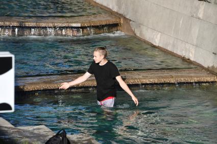 Москва.   Молодой человек купается в фонтане.