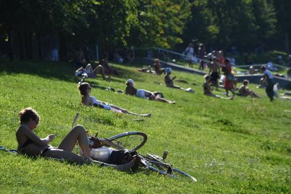 Москва.   Горожане отдыхают в парке на газоне.