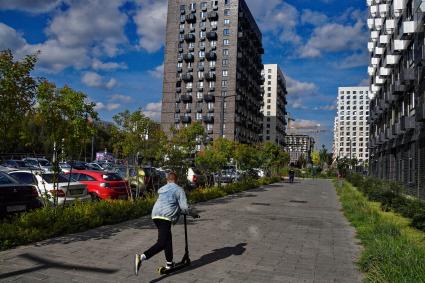 Москва.  Мальчик на самокате во дворе жилого комплекса.