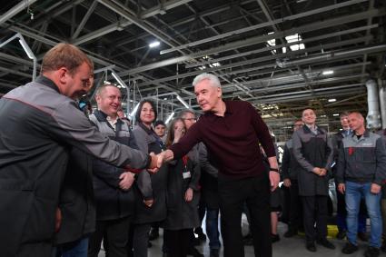 Москва.  Мэр Москвы Сергей Собянин (в центре) общается с рабочими во время церемонии запуска серийной сборки новой модели автомобилей - седана `Москвич 6`на территории Московского автомобильного завода `Москвич`.