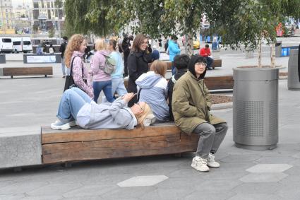 Москва.   Прохожие отдыхают на скамейке.